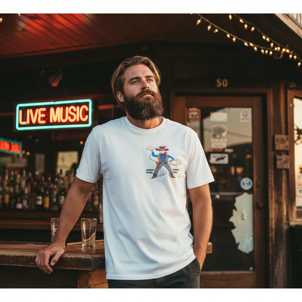 Man wearing a white t-shirt with a playful cowboy graphic design in front of a bar with a 'Live Music' sign.