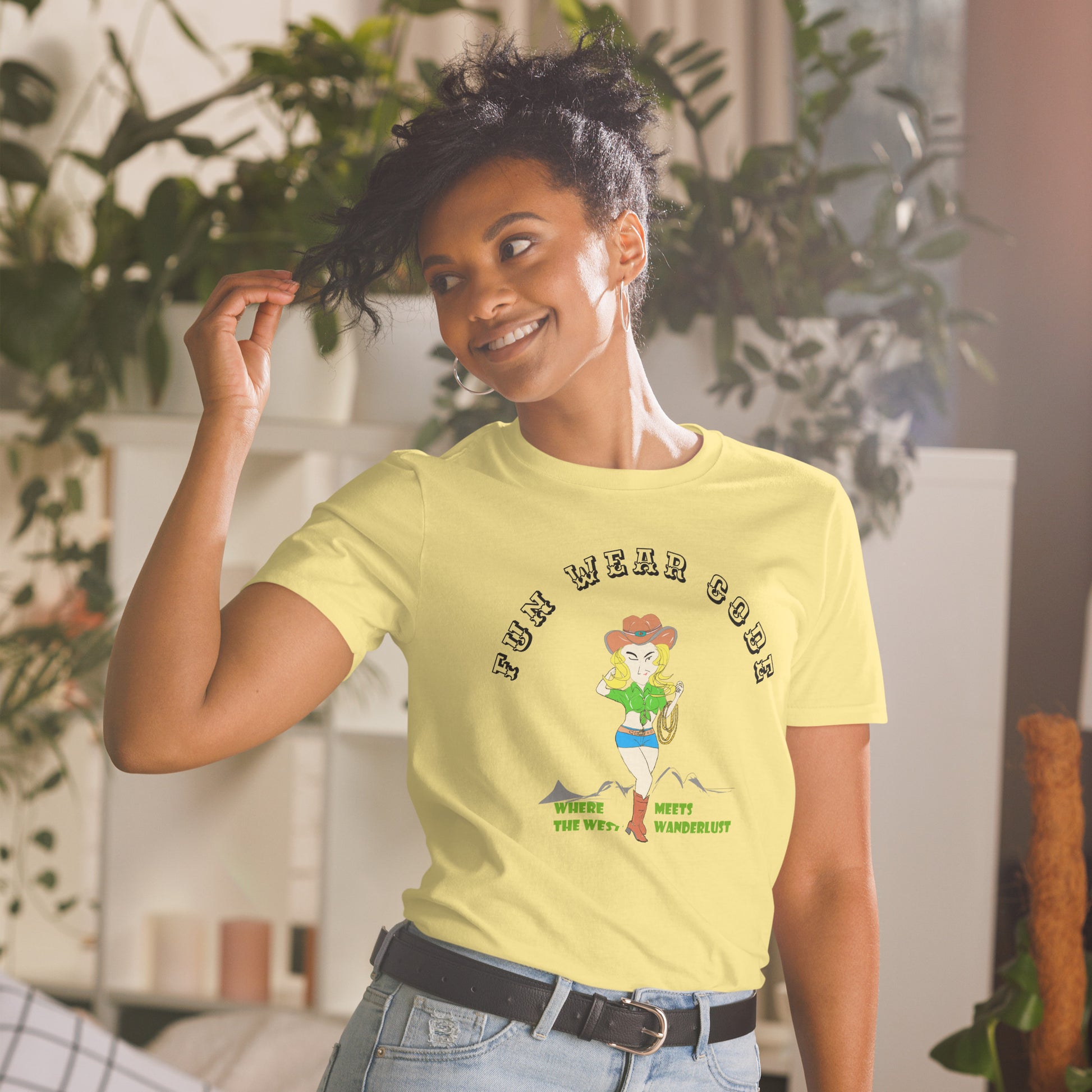 Woman wearing a yellow tee with a graphic of a cowgirl and text "Fun Wear Code" on a plants background