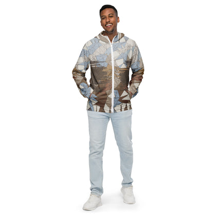 Man wearing a geometric patterned windbreaker and light blue jeans on a white background