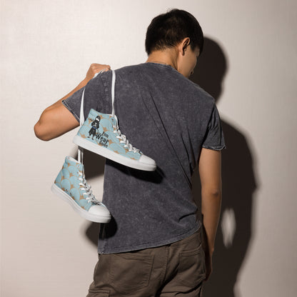 Person holding a pair of light blue high-top sneakers with a ninja graphic and 'Fun Wear Code' text logo, and white soles against a plain background